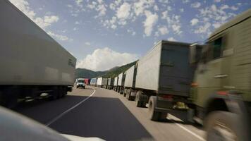 Tiflis, Georgia - - September 19, 2022 pov Auto fährt entlang das georgisch Autobahn Vergangenheit ein groß der Verkehr Marmelade von Trucker und Lastwagen. video