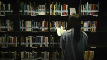 un mujer mirando para libros a estudiar a el banco de Tailandia aprendizaje centrar edificio para servicios a personas video