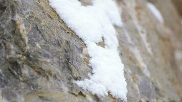 snö skikten ackumuleras på sten i de hård stormig kall väder i vinter- video