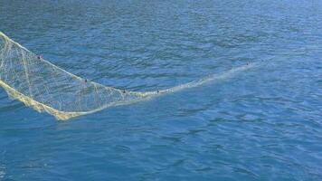 un' netto via è gettato in il mare a partire dal un' piccolo pesca barca video