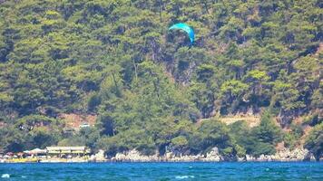 kiteboarding, kite kiter och kiteboarder är drog tvärs över hav vatten förbi en vind kraft drake video