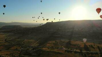 antenn varm luft ballonger flygande över huva fe- skorstenar i cappadocia Kalkon på soluppgång morgon- video