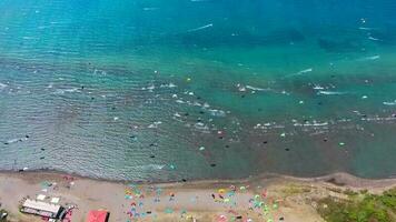 kiteboarding, kite kiters och kiteboardåkare är drog tvärs över hav vatten förbi en vind kraft drake video