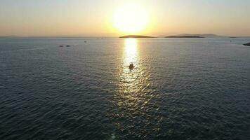 Fishing Boat Sailing at Sunset and Reflection of Evening Sun on the Sea video