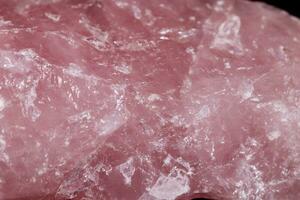 Macro mineral stone Pink quartz on black background photo