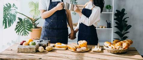 Young happy couple is enjoying and preparing healthy meal in their kitchen and reading recipes on the laptop. photo