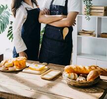 joven contento Pareja es disfrutando y preparando sano comida en su cocina y leyendo recetas en el ordenador portátil. foto