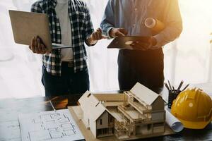 construcción y estructura concepto de ingeniero trabajando dibujo en Plano reunión para proyecto trabajando con compañero en modelo edificio y Ingenieria herramientas en trabajando sitio, construcción concepto. foto