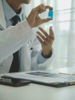 Doctor sitting at desk and writing a prescription for her patient photo