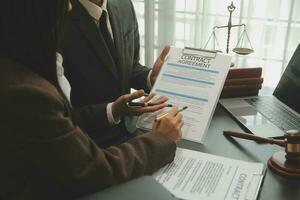 Business and lawyers discussing contract papers with brass scale on desk in office. Law, legal services, advice, justice and law concept picture with film grain effect photo