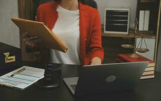 Business and lawyers discussing contract papers with brass scale on desk in office. Law, legal services, advice, justice and law concept picture with film grain effect photo