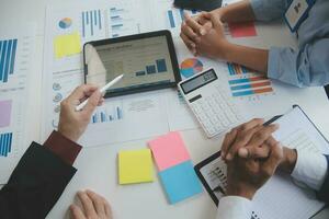 Financial analysts analyze business financial reports on a digital tablet planning investment project during a discussion at a meeting of corporate showing the results of their successful teamwork. photo