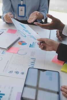 Financial analysts analyze business financial reports on a digital tablet planning investment project during a discussion at a meeting of corporate showing the results of their successful teamwork. photo