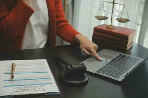 Business and lawyers discussing contract papers with brass scale on desk in office. Law, legal services, advice, justice and law concept picture with film grain effect photo