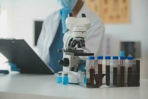 Professional lab. Amazing longhaired medical worker wearing uniform while using microscope during research photo