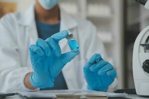 Professional lab. Amazing longhaired medical worker wearing uniform while using microscope during research photo