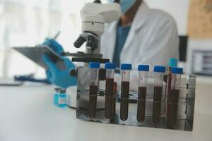 Professional lab. Amazing longhaired medical worker wearing uniform while using microscope during research photo