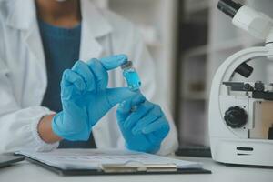 Professional lab. Amazing longhaired medical worker wearing uniform while using microscope during research photo