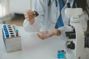 Professional lab. Amazing longhaired medical worker wearing uniform while using microscope during research photo