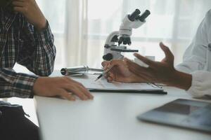 Professional lab. Amazing longhaired medical worker wearing uniform while using microscope during research photo