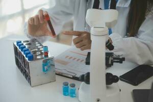 Professional lab. Amazing longhaired medical worker wearing uniform while using microscope during research photo