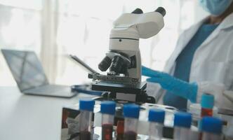 Professional lab. Amazing longhaired medical worker wearing uniform while using microscope during research photo