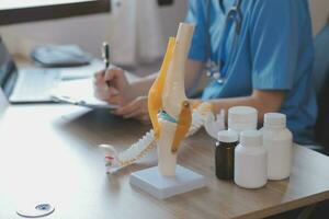 Doctor and patient talking while sitting at the desk in hospital office, closeup of human hands. Medicine and health care concept photo