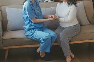 Cropped shot of a female nurse hold her senior patient's hand. Giving Support. Doctor helping old patient with Alzheimer's disease. Female carer holding hands of senior man photo