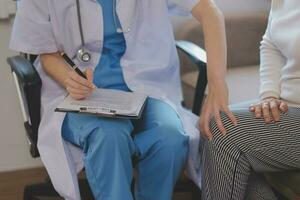 Doctor and patient talking while sitting at the desk in hospital office, closeup of human hands. Medicine and health care concept photo