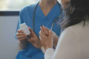 Cropped shot of a female nurse hold her senior patient's hand. Giving Support. Doctor helping old patient with Alzheimer's disease. Female carer holding hands of senior man photo