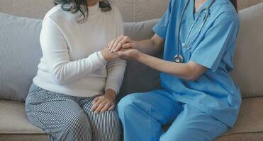 recortado Disparo de un hembra enfermero sostener su mayor del paciente mano. dando apoyo. médico Ayudar antiguo paciente con Alzheimer enfermedad. hembra cuidador participación manos de mayor hombre foto