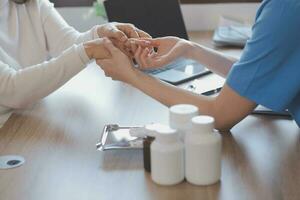 Cropped shot of a female nurse hold her senior patient's hand. Giving Support. Doctor helping old patient with Alzheimer's disease. Female carer holding hands of senior man photo