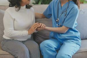 Cropped shot of a female nurse hold her senior patient's hand. Giving Support. Doctor helping old patient with Alzheimer's disease. Female carer holding hands of senior man photo