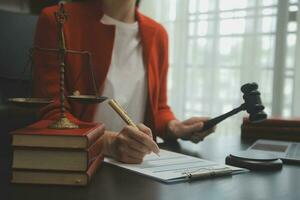 Business and lawyers discussing contract papers with brass scale on desk in office. Law, legal services, advice, justice and law concept picture with film grain effect photo