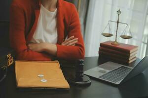 Business and lawyers discussing contract papers with brass scale on desk in office. Law, legal services, advice, justice and law concept picture with film grain effect photo