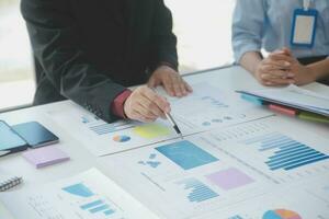 Financial analysts analyze business financial reports on a digital tablet planning investment project during a discussion at a meeting of corporate showing the results of their successful teamwork. photo