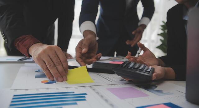 Financial analysts analyze business financial reports on a digital tablet planning investment project during a discussion at a meeting of corporate showing the results of their successful teamwork. photo