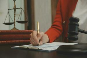 Business and lawyers discussing contract papers with brass scale on desk in office. Law, legal services, advice, justice and law concept picture with film grain effect photo