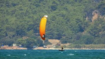 Kitesurfen, Kitesurfen Kiter und Kiteboarder ist gezogen über Meer Wasser durch ein Wind Leistung Drachen video