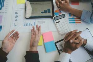 Financial analysts analyze business financial reports on a digital tablet planning investment project during a discussion at a meeting of corporate showing the results of their successful teamwork. photo