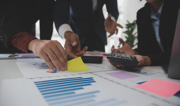 Financial analysts analyze business financial reports on a digital tablet planning investment project during a discussion at a meeting of corporate showing the results of their successful teamwork. photo