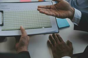 Financial analysts analyze business financial reports on a digital tablet planning investment project during a discussion at a meeting of corporate showing the results of their successful teamwork. photo