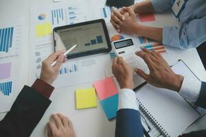 Financial analysts analyze business financial reports on a digital tablet planning investment project during a discussion at a meeting of corporate showing the results of their successful teamwork. photo