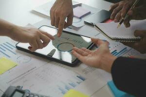 Financial analysts analyze business financial reports on a digital tablet planning investment project during a discussion at a meeting of corporate showing the results of their successful teamwork. photo
