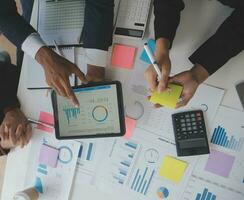 Financial analysts analyze business financial reports on a digital tablet planning investment project during a discussion at a meeting of corporate showing the results of their successful teamwork. photo