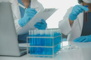 Health care researchers working in life science laboratory. Young female research scientist and senior male supervisor preparing and analyzing microscope slides in research lab. photo