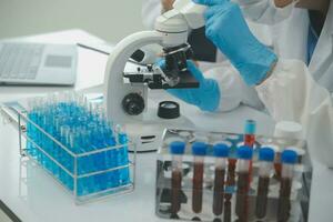 investigadores de atención médica que trabajan en el laboratorio de ciencias de la vida. joven científica investigadora y supervisora masculina senior preparando y analizando portaobjetos de microscopio en el laboratorio de investigación. foto