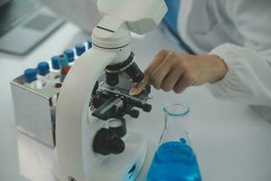 Health care researchers working in life science laboratory. Young female research scientist and senior male supervisor preparing and analyzing microscope slides in research lab. photo