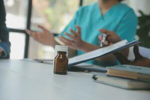 médico equipo teniendo un reunión con doctores en blanco laboratorio abrigos y quirúrgico matorrales sentado a un mesa que se discute un pacientes registros, éxito médico salud cuidado, medicina del doctor trabajando concepto foto