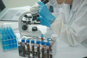 investigadores de atención médica que trabajan en el laboratorio de ciencias de la vida. joven científica investigadora y supervisora masculina senior preparando y analizando portaobjetos de microscopio en el laboratorio de investigación. foto